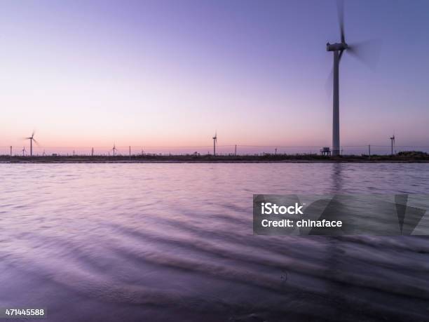 Wind Turbine And Electrical Towers On Sunset Stock Photo - Download Image Now - 2015, American-Style Windmill, Cable