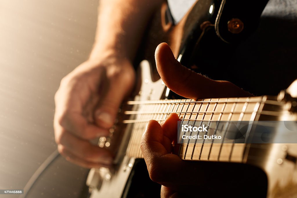 Close up of mans fingers playing electric guitar Hands of man playing electric guitar. Bend technique. Low key photo. Guitar Stock Photo