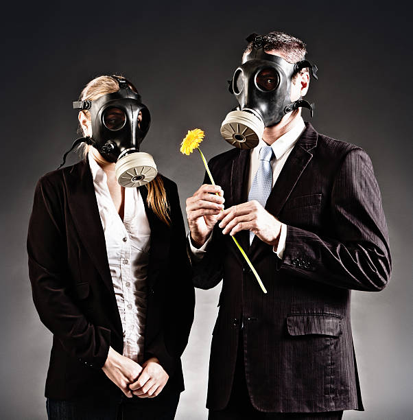 formalnie ubrany para w maski gazowe z żółty kwiat - re2012019 zdjęcia i obrazy z banku zdjęć