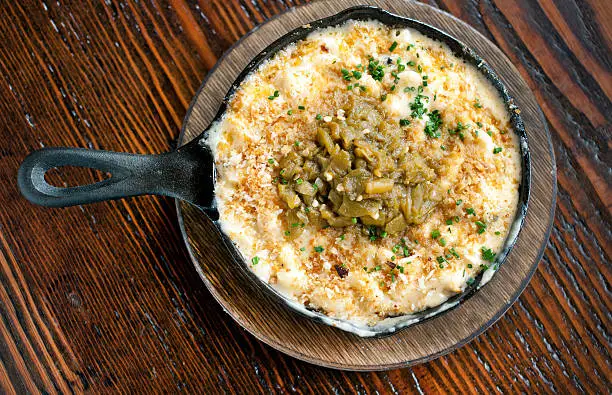 Baked southwestern style mac n cheese with roasted green chiles and bread crumbs.  Served hot out of the oven in a cast iron skillet.