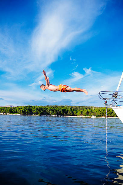istock young man jumping off the yacht 471446873
