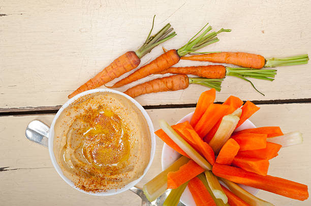 fresh hummus dip with raw carrot and celery