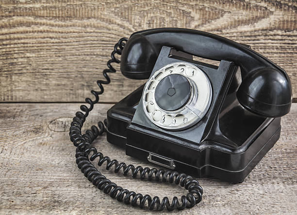 istock Retro rotary phone black color on wooden background 471449014