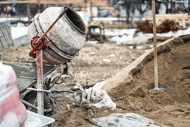istock Concrete mixer, sand and tools at building site 471453126
