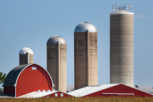 Rural Farm Illustrating Growth and Success.  The silos get bigger and bigger from old to new.  Somebody has been a very successful farmer and business person.