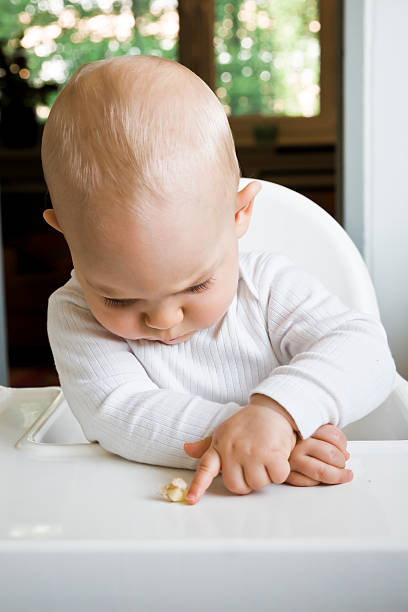 istock Baby Eating in High Chair 471453839