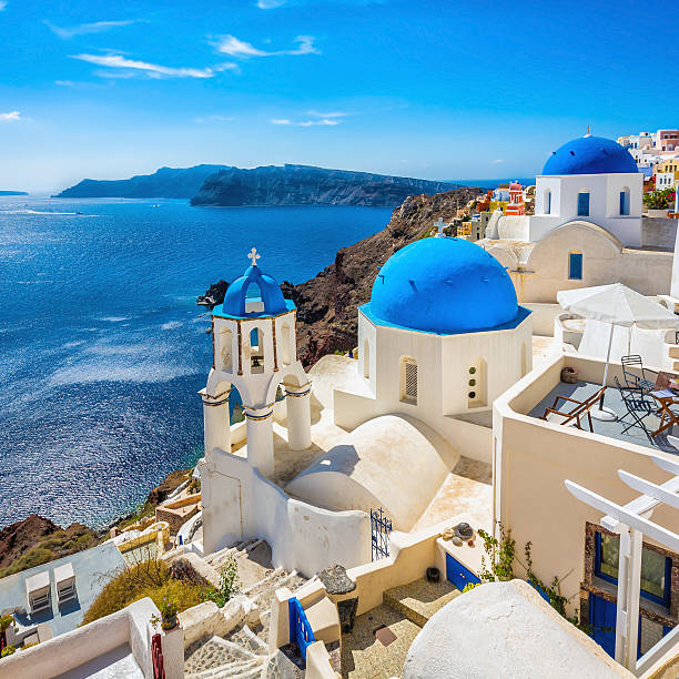 blue dome kirchen von santorin, griechenland - hat oia europe vacations stock-fotos und bilder