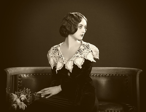 Vintage Studio headshot of a pensive young woman looking down