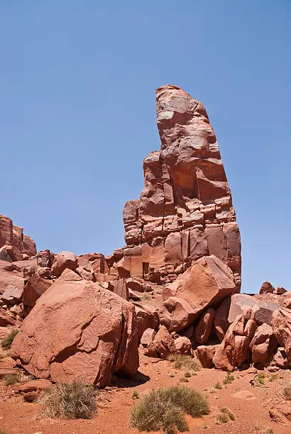 Monument Valley, on the Arizona - Utah border, gives us some of the most iconic and enduring images of the American Southwest. The harsh empty desert is punctuated by many colorful sandstone rock formations. It can be a photographer's dream to capture the ever-changing play of light on the buttes and mesas. Even to the first-time visitor, Monument Valley will probably seem very familiar. This rugged landscape has achieved fame in the movies, advertising and brochures. It has been filmed and photographed countless times over the years. If a movie producer was looking for a landscape that epitomizes the Old West, a better location could not be found. This picture of The Thumb was photographed from the Monument Valley Road north of Kayenta, Arizona, USA.