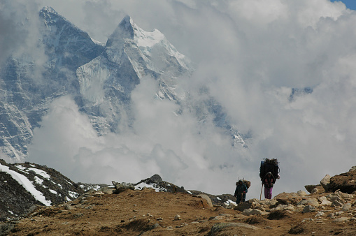 Everest, Nepal - May 3, 2006: Sherpas carrying baggage and supply to the Everest base camp, Nepal Himalayas 