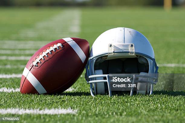 Foto de Americana De Futebol Capacete Em Campo e mais fotos de stock de Bola - Bola, Capacete de Futebol Americano, Artigo de vestuário para cabeça