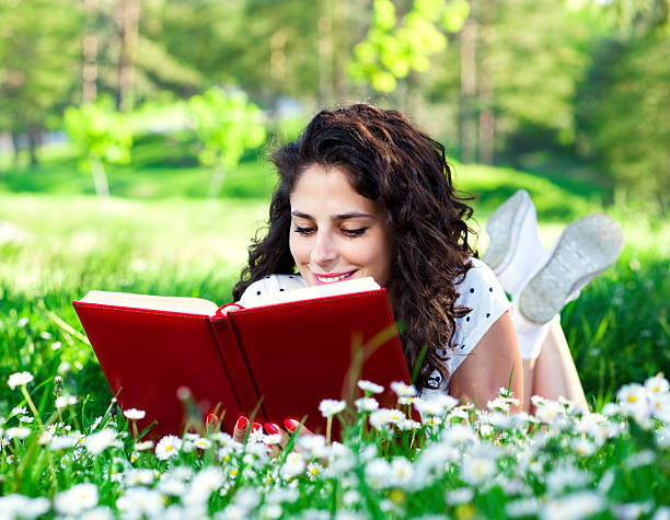 istock Young Woman lying on the grass and reading 471456801