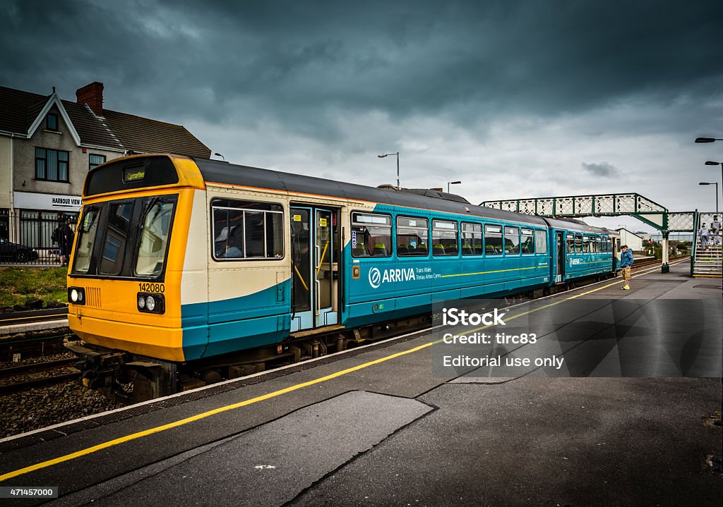 Arriva Wales local train at Welsh station Burry Port, UK - April 25, 2015: Arriva Wales local train at Welsh station. Passengers are pictured crossing the footbridge after coming off the train Train - Vehicle Stock Photo