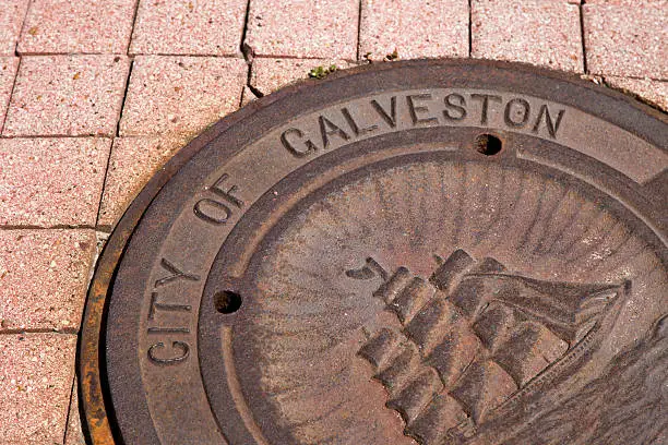 A galveston city man hole cover with tall ship on the front