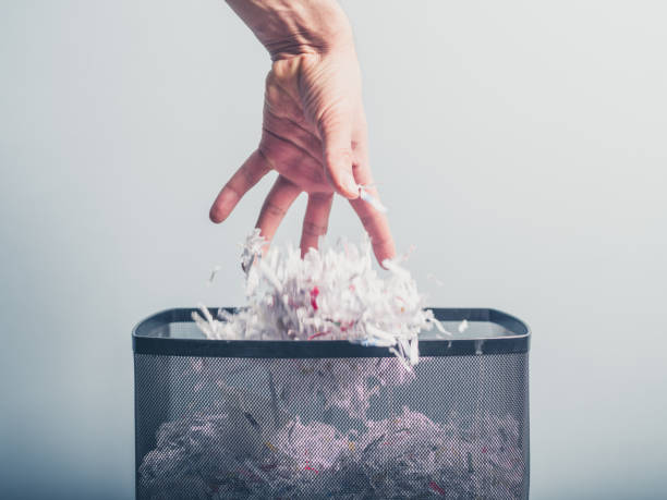 istock Hand putting shredded paper in basket 471458232