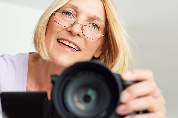 зрелая женщина с помощью камеры - home video camera women videographer digital video camera стоковые фото и изображения