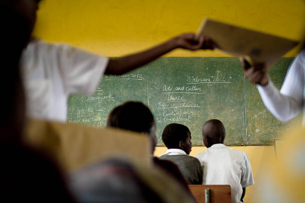 южноафр�иканский учитель руки, книг в своем классе - education blackboard child teacher стоковые фото и изображения