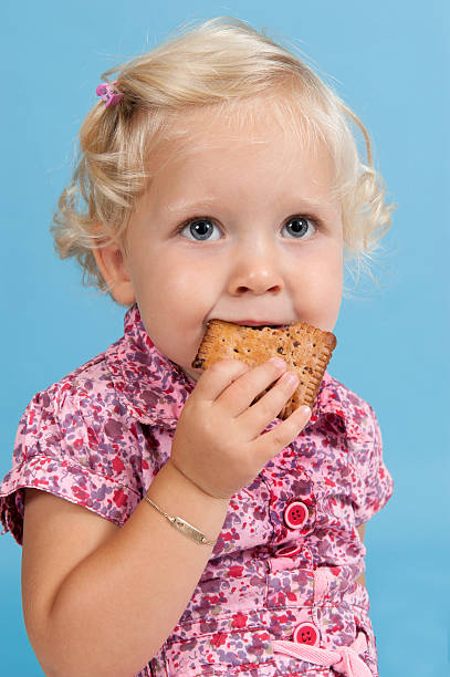 istock Little girl eating a biscuit. 471461021
