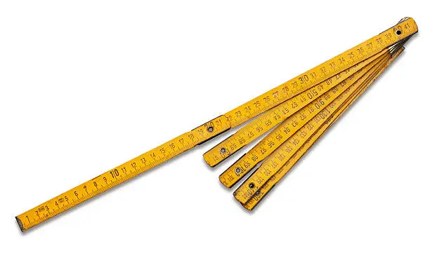 A yellow wooden folding ruler. Shows signs of long using. Isolated on white. Clipping path included.