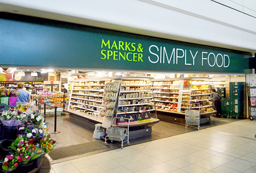 Gatwick, London, UK - August 31, 2012: A Marks and Spencer food shop in the South Terminal of Gatwick Airport, London UK - one of two at the airport. Originally a clothing retailer established in 1884, the company is now a major food retailer with shops in many airports, railway and filling stations. People can be seen waiting near the till to pay.
