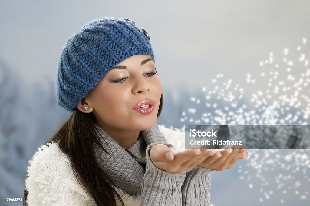 Winter snowing Beautiful young woman blowing snowfalkes from her hands in a winter day outdoor 20-29 Years Stock Photo