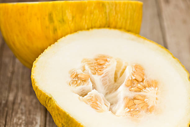 Married Melon A high angle close up of a cross section of a ripe casaba melon. yellow melons field stock pictures, royalty-free photos & images