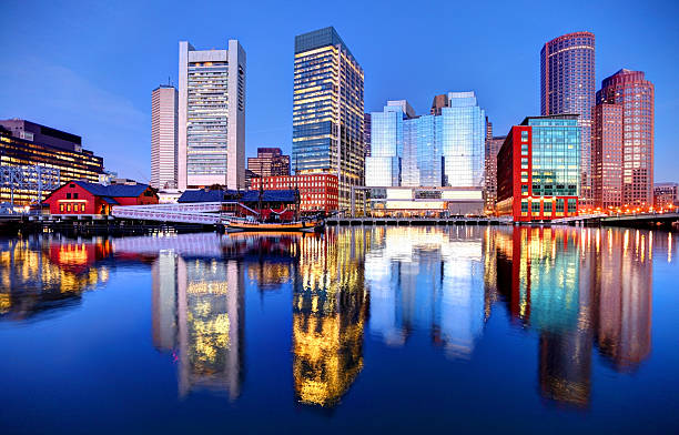 Boston Skyline Boston downtown skyline refection on the harbor waterfront from the Fort Point neighborhood. The Boston cityscape is a mixture of old and new buildings. Boston is known for its central role in American history, world-class educational institutions, cultural facilities, and champion sports franchises. harborwalk stock pictures, royalty-free photos & images