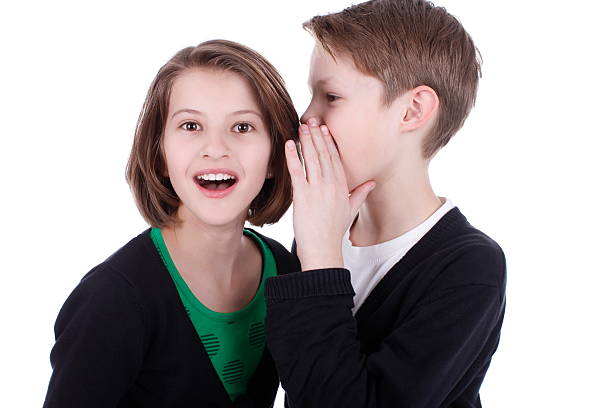 istock Boy whispers secrets in the girls ear 471465320