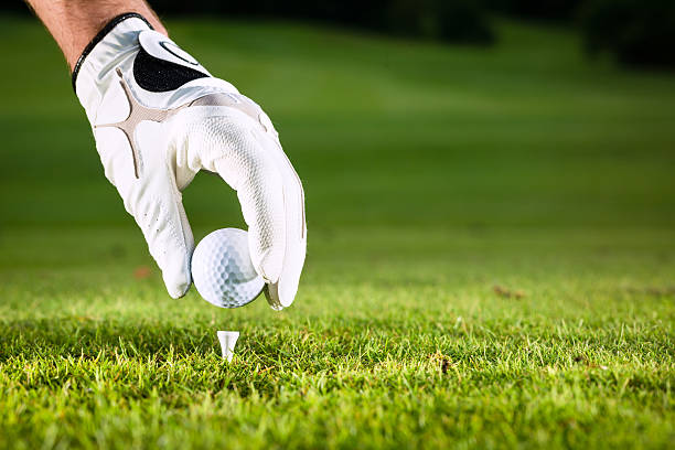 istock Gloved hand placing a golf ball on a tee on a golf course 471465329