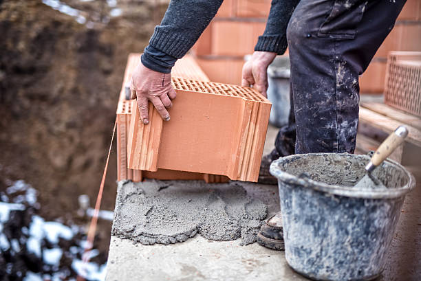istock Construction site, worker building brick walls with trowel, cement, mortar 471465576