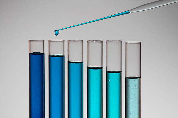 istock Chemical drop at a laboratoy falling inside the test tubes 471468665
