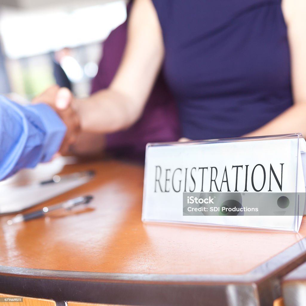 Closeup of Registration desk with people shaking hands Closeup of Registration desk with people shaking hands.  Adult Stock Photo