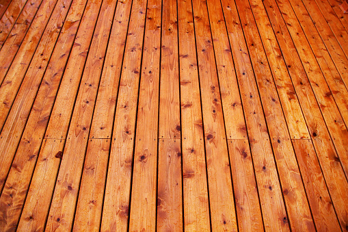Brilliant red cedar deck, newly treated with a state-of-the-art wood treatment, repels and beads water.