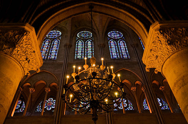 Inside the Notre-Dame de Reims Inside the Notre-Dame de Reims, looking at the beautiful stained glass windows, with a chandelier in the foreground. notre dame de strasbourg stock pictures, royalty-free photos & images