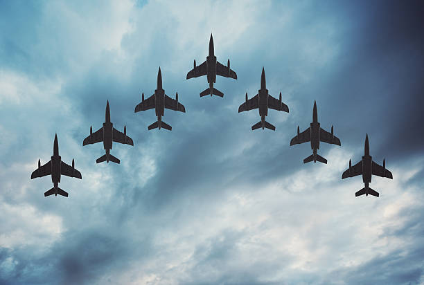 Fighter Jets in Formation Fighter jets arranged in a V shaped flying formation under dramatic overcast skies.  Composite image. supersonic airplane photos stock pictures, royalty-free photos & images