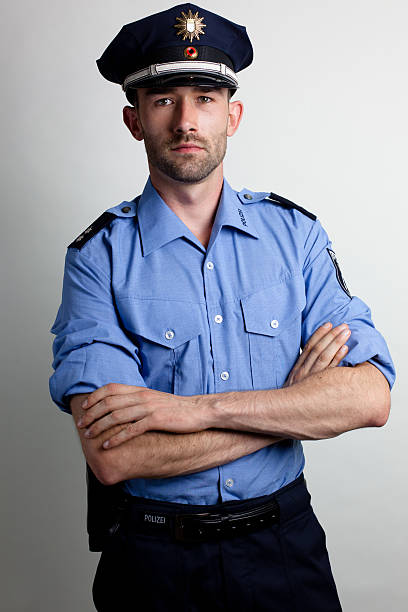 Retrato de un policía en azul uniforme brazos cruzados - foto de stock