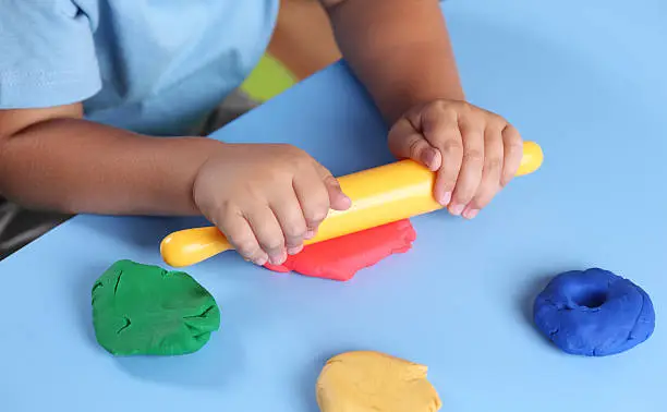 Photo of Child playing with modeling clay