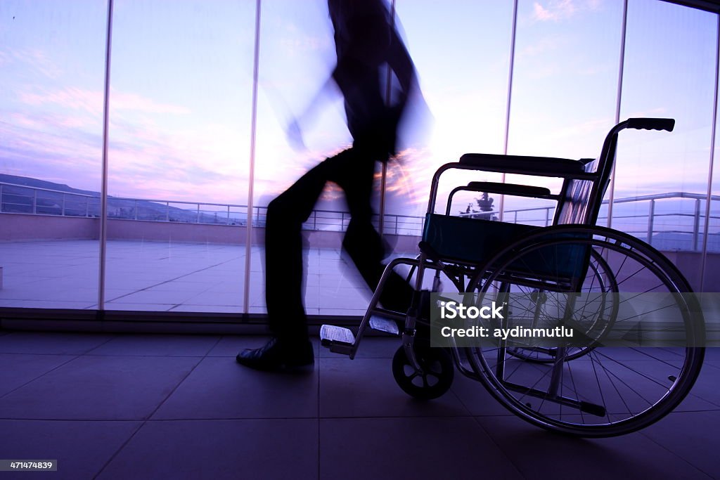 Disabled Person Disabled man rises from wheelchair. Paraplegic Stock Photo