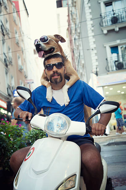 man and his dog posing on motorcycle