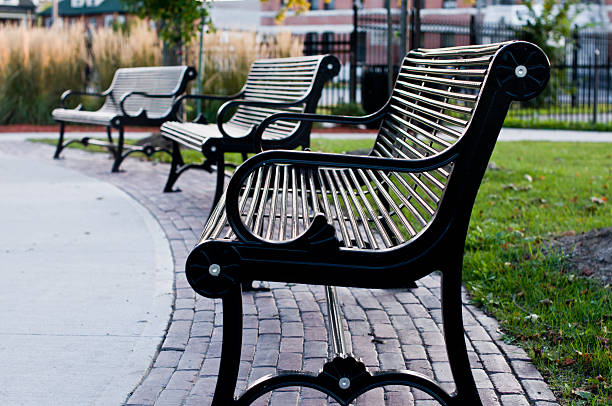 istock park benches row bricks sidewalk path grass buildings fences metal 471475511