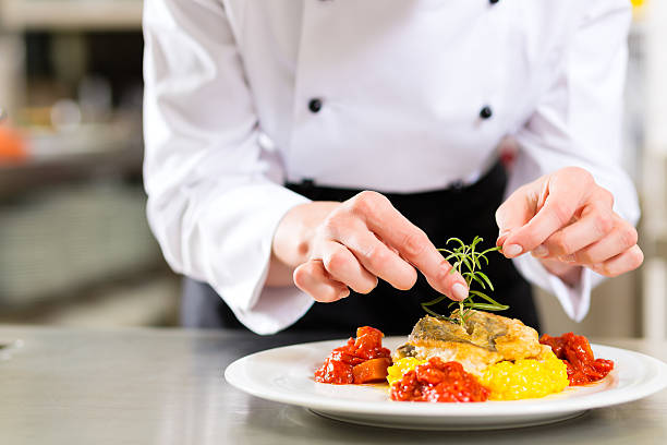 feminino chef de cozinha do restaurante de cozinha - prepared fish - fotografias e filmes do acervo