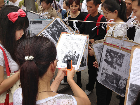 Xi'an, China - September 15, 2012: Chinese students and protestors use mobile phones to photograph and share anti-Japanese posters during Chinese demonstrations against Japan's purchase of the Diaoyu Islands.