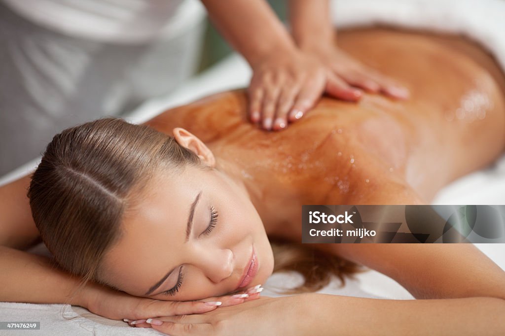 Enjoying in massage Young carefree woman receiving hot chocolate massage at spa and beauty salon Adult Stock Photo