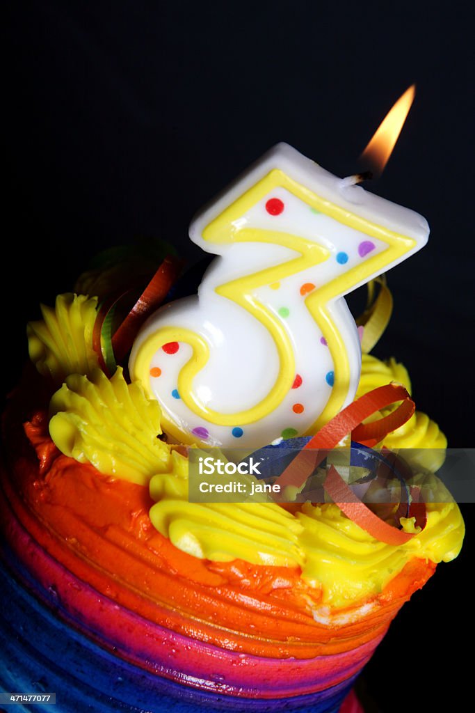 3rd Birthday Cake A colorful birthday cake on a black background with a "3" candle Aging Process Stock Photo
