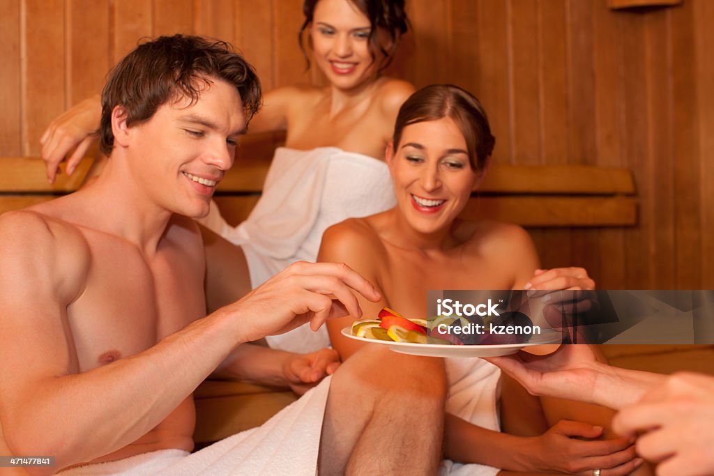 Quattro persone o gli amici nella sauna - Foto stock royalty-free di Accudire