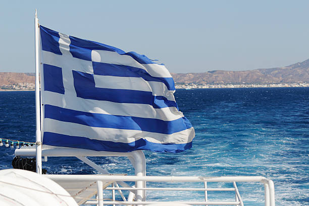 istock blue sky with greek flag aginst ocean and island 471478396