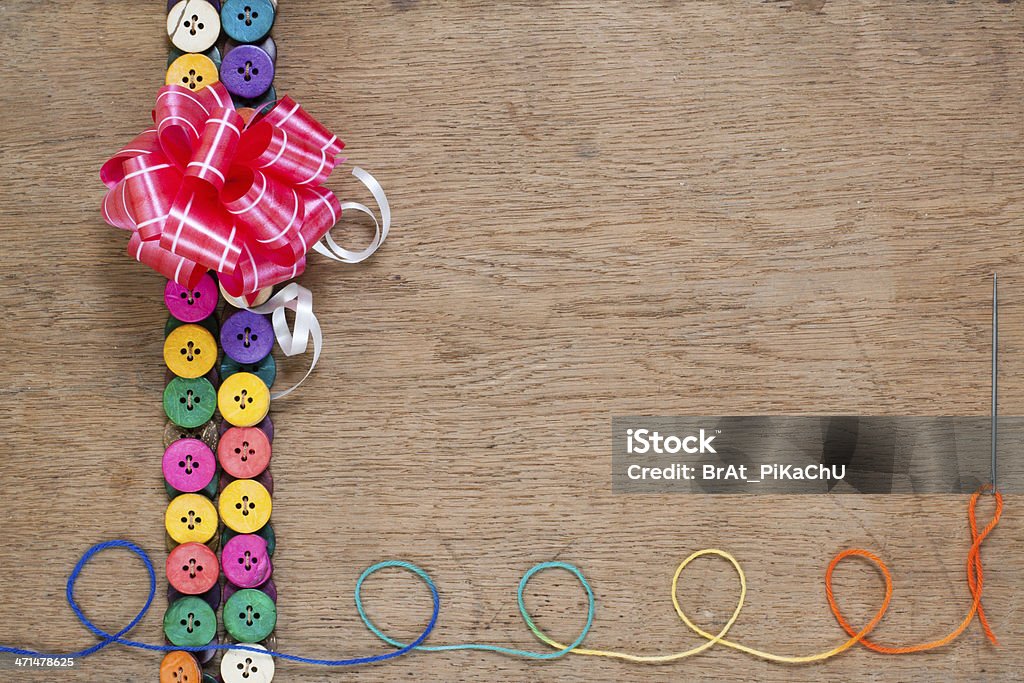 Cadeau bow, coloré boutons, des fils avec aiguille sur bois - Photo de Coudre libre de droits