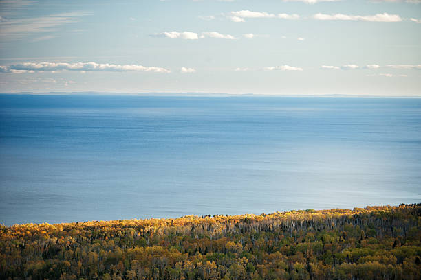 Lake Superior from Minnesota's North Shore. Minnesota's "North Shore" on Lake Superior. This image is in early October with an expansive view out over the colorful shoreline to the vast blue water of Lake Superior. The Wisconsin shoreline can be seen in the distance. north shore stock pictures, royalty-free photos & images