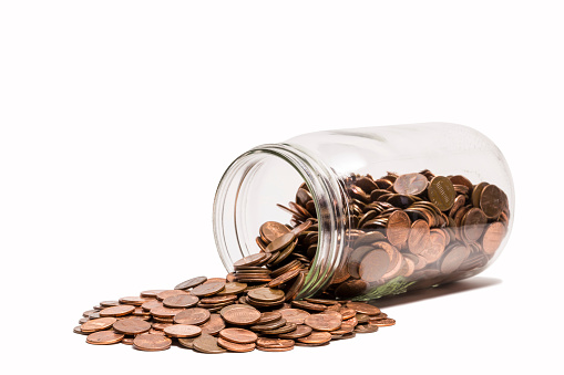 A glass jar of pennies tipped over.