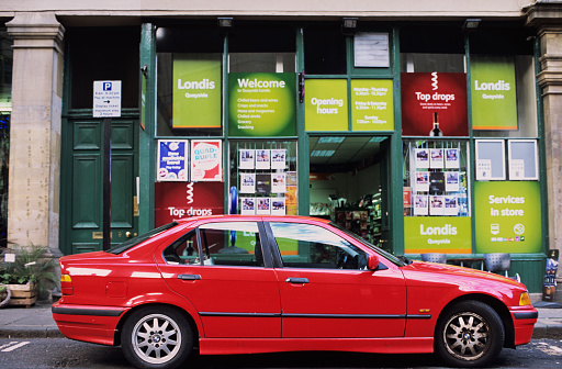 Newcastle-upon-Tyne, England - September 29, 2012: this 3-Series (codenamed E46) BMW car is parked in front of a colourful Landis shop in Queen St. that perfectly complements the vivid colour of the automobile.